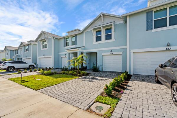 A row of light blue townhouses with paved driveways and white garage doors — 419 Salisbury Circle, Fort Pierce FL 34982, FORT PIERCE, FL