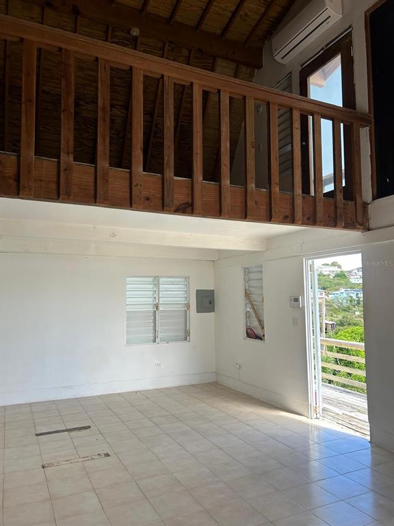 An interior view of a room with tiled floors, a wooden loft railing, and a balcony — Catalina Ortis CATALINA ORTIZ UNIT 108, CULEBRA, PR