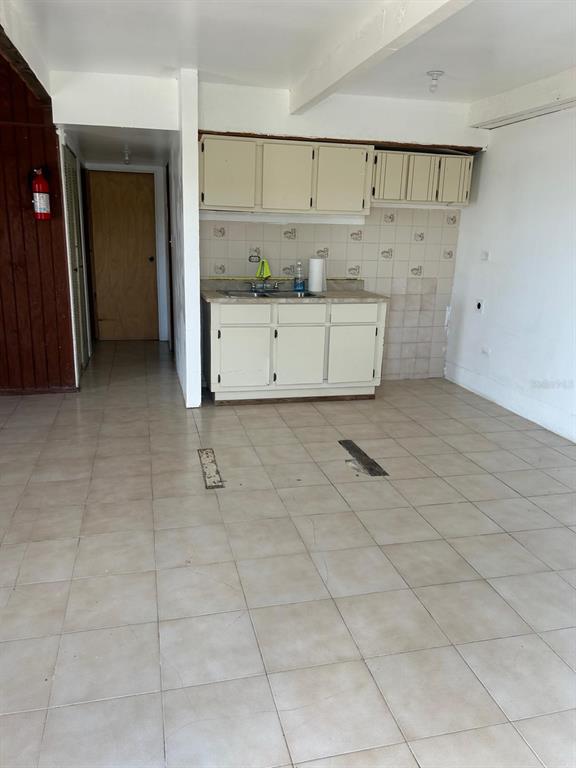 A kitchen area features beige cabinets, a sink, and tiled flooring in an open room — Catalina Ortis CATALINA ORTIZ UNIT 108, CULEBRA, PR