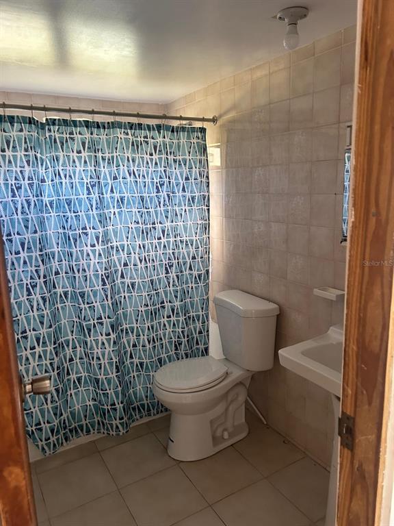 A bathroom features a blue patterned shower curtain, a white toilet, and a pedestal sink — Catalina Ortis CATALINA ORTIZ UNIT 108, CULEBRA, PR