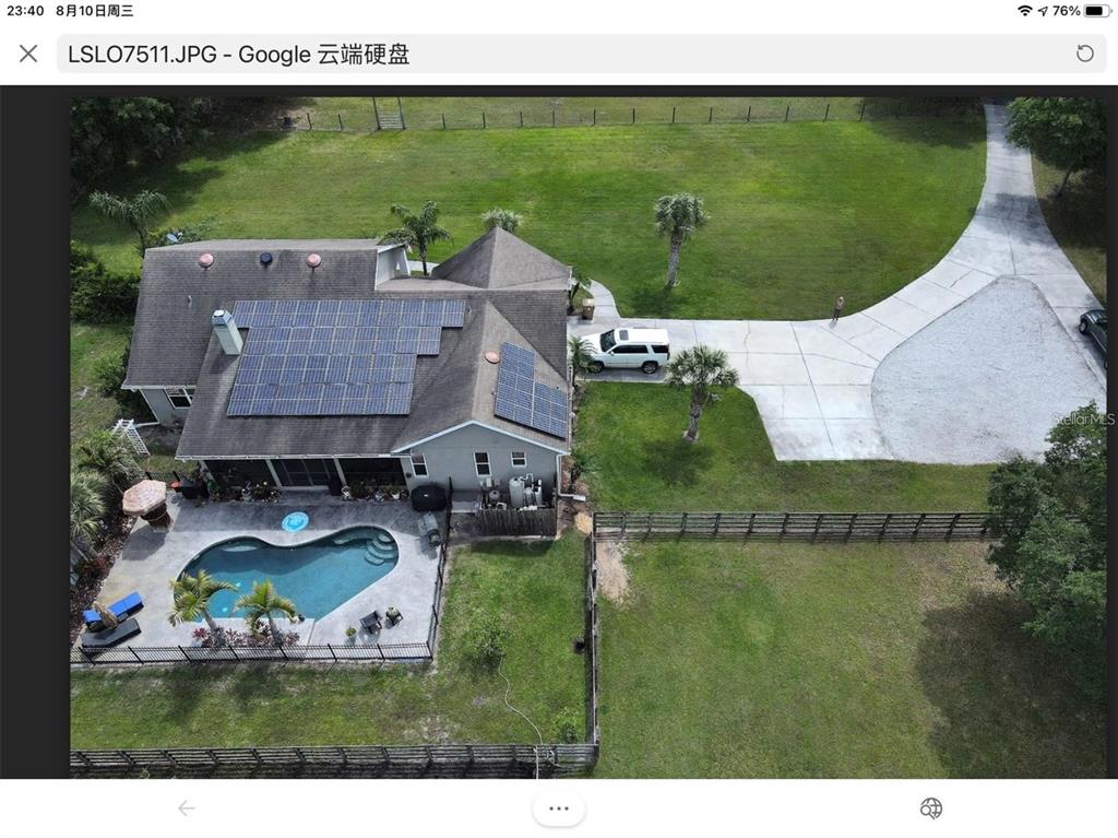 An aerial view of a house with solar panels, a swimming pool, and a large yard — 3060 RAMBLER AVENUE, ST CLOUD, FL