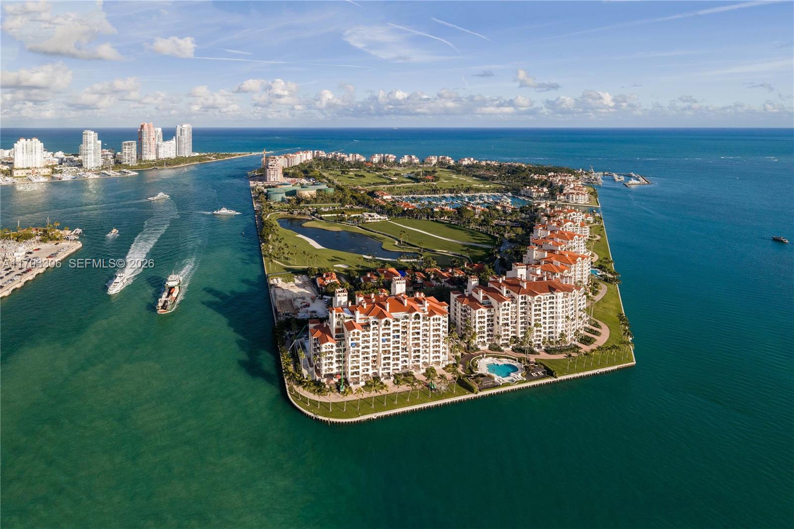 An aerial view shows a residential island complex with Mediterranean-style buildings, a golf course, and marina — 1006 Links Drive, Miami Beach FL 33109, MIAMI BEACH, FL