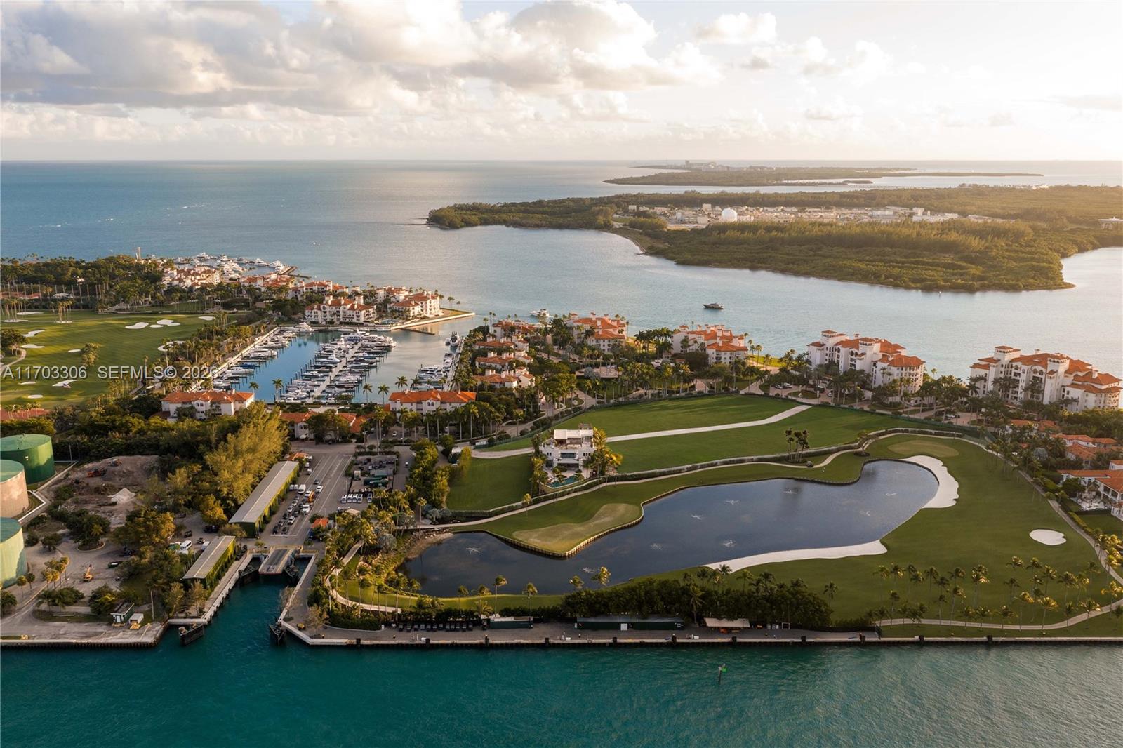 An aerial view shows a coastal residential community with a marina, golf course, and lake — 1006 Links Drive, Miami Beach FL 33109, MIAMI BEACH, FL