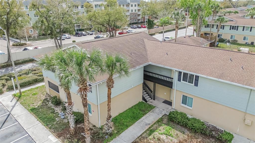 An aerial view of a two-story apartment building with palm trees and a parking lot — 202 RED MAPLE PLACE UNIT 202, BRANDON, FL