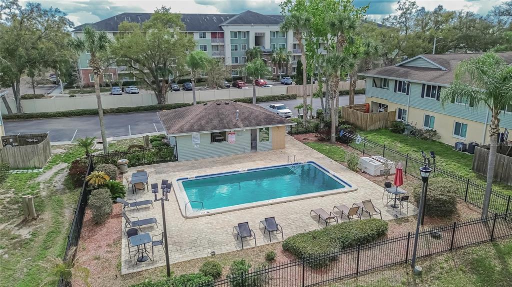 An aerial view of a rectangular swimming pool surrounded by a patio, lounge chairs, and fencing — 202 RED MAPLE PLACE UNIT 202, BRANDON, FL