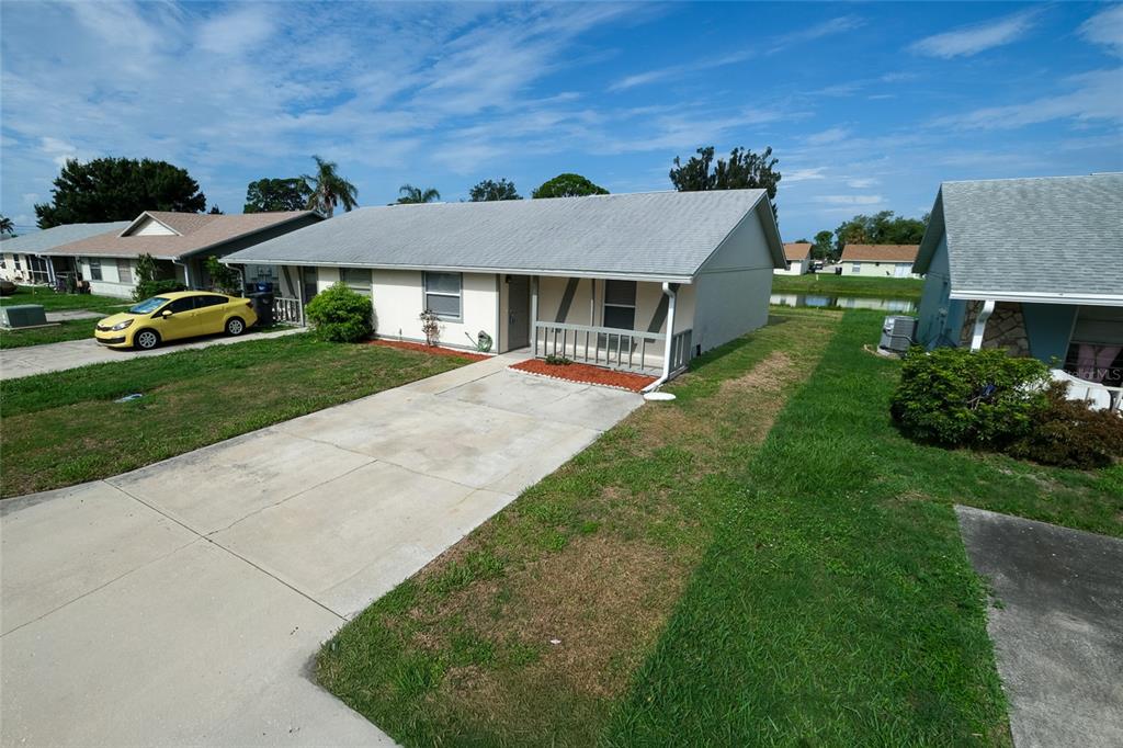 A single-story house with a concrete driveway, a small front porch, and a gray roof — 4304 78TH STREET W UNIT 54, BRADENTON, FL