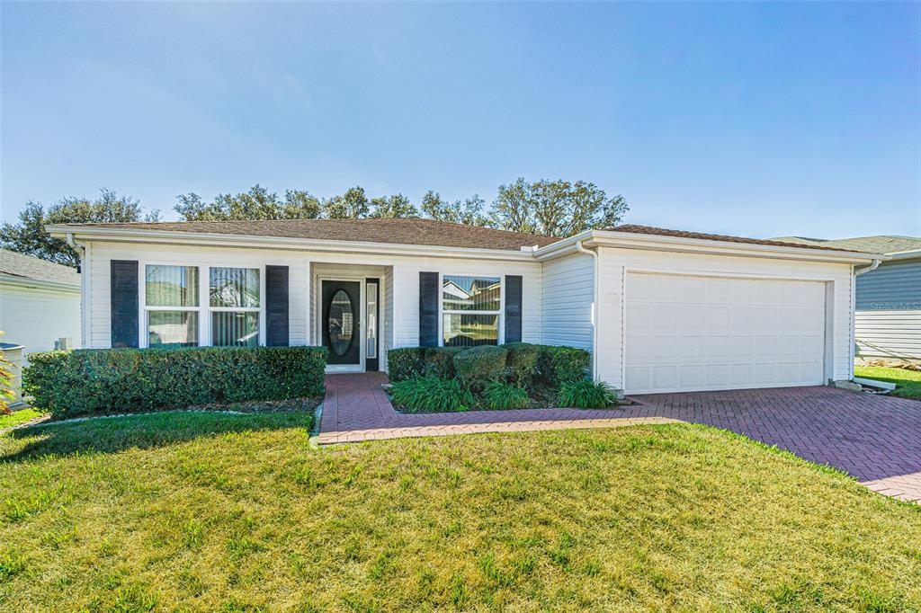 A single-story house with white siding, black shutters, a front door, and a two-car garage — 29140 PRINCEVILLE DRIVE, SAN ANTONIO, FL