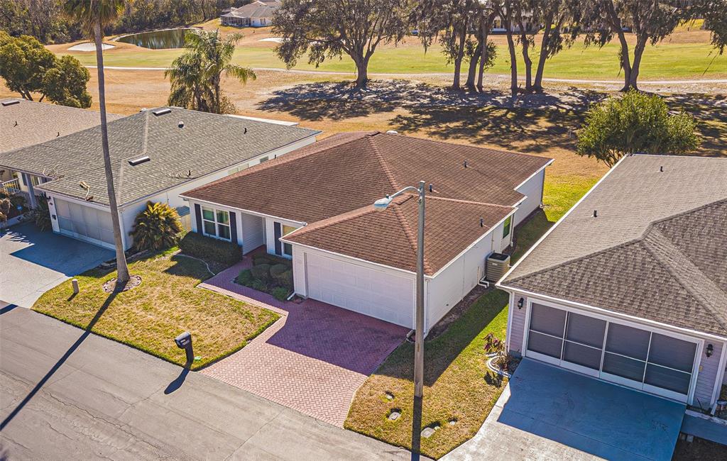 An empty living room features light wood-look flooring, vaulted ceilings, and a ceiling fan — 29140 PRINCEVILLE DRIVE, SAN ANTONIO, FL