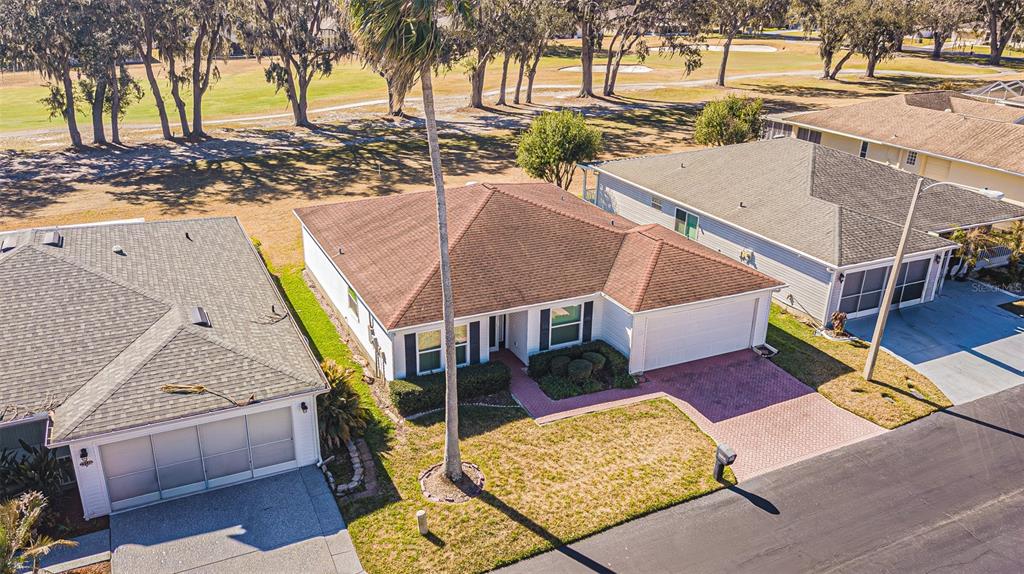 An empty room with light blue walls, wood-look flooring, and a white door — 29140 PRINCEVILLE DRIVE, SAN ANTONIO, FL