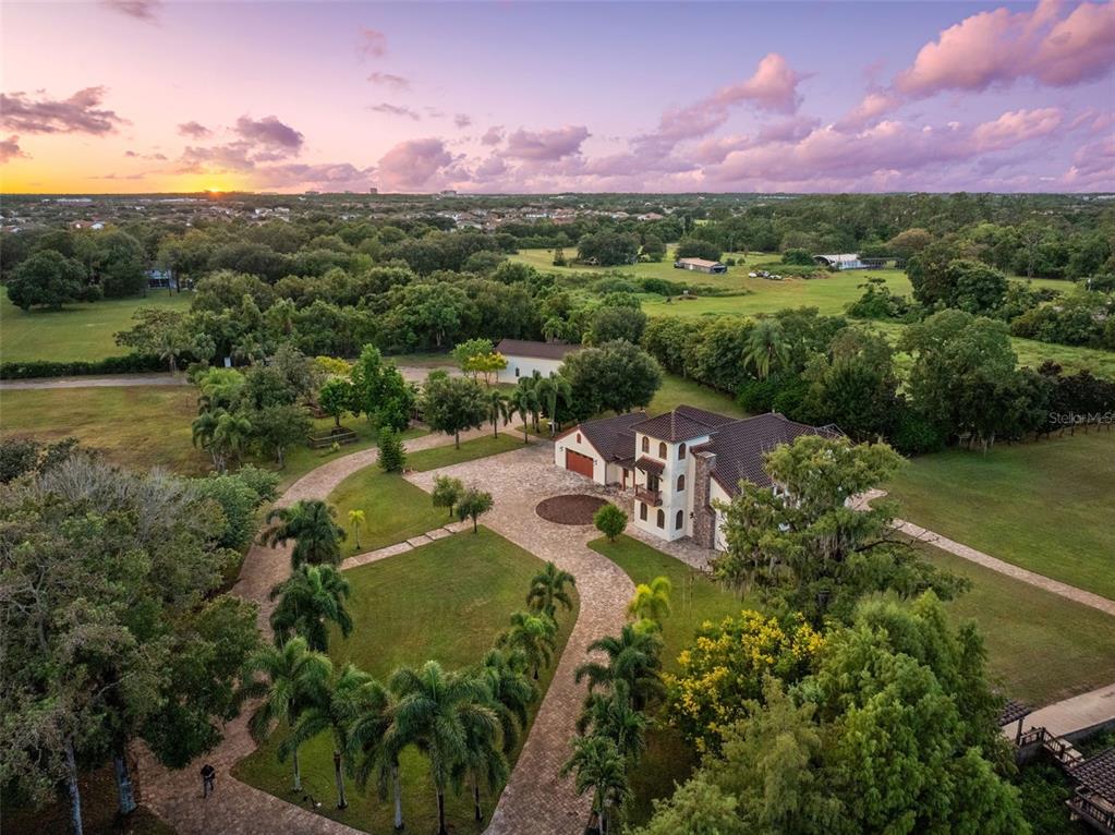 An aerial view shows a large house with a paved driveway surrounded by green lawns — 11205 TINDALL ROAD, ORLANDO, FL