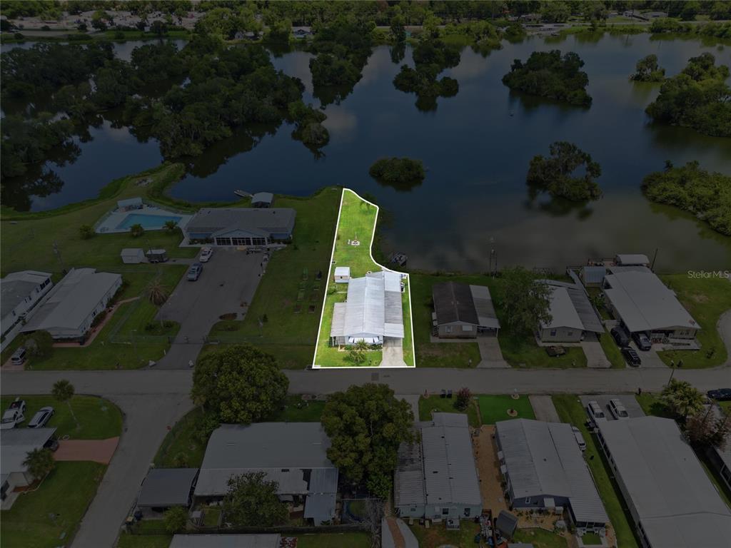An aerial view shows a single-story house with a highlighted lot bordering a lake — 3586 LAZY LAKE DRIVE N, LAKELAND, FL