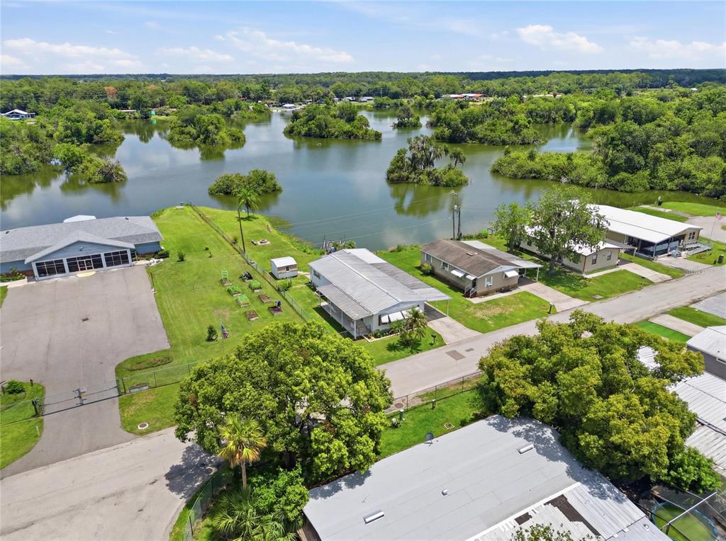 An aerial view shows several houses near a lake with scattered small islands — 3586 LAZY LAKE DRIVE N, LAKELAND, FL