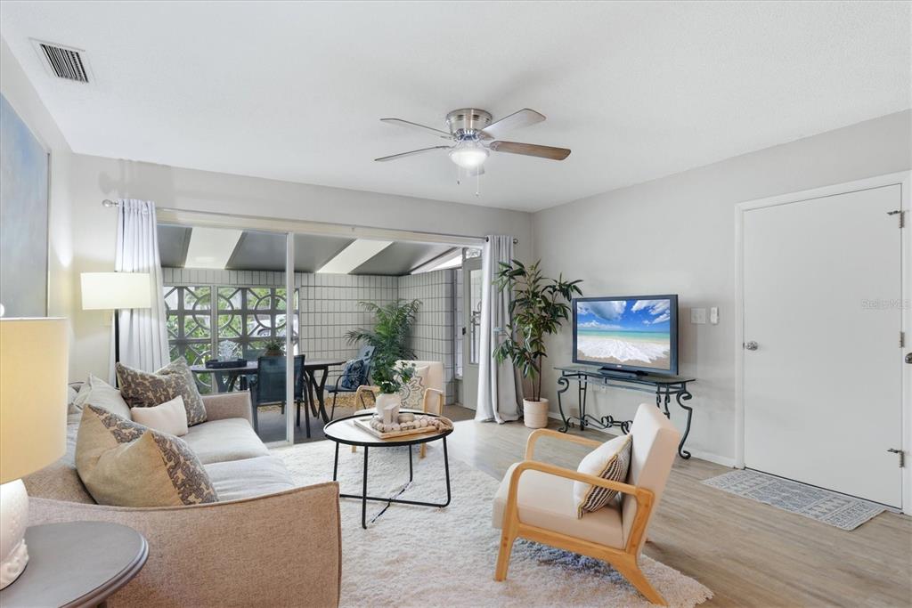 A living room features a sofa, armchairs, a coffee table, and a sliding glass door — 405 MENENDEZ STREET, VENICE, FL