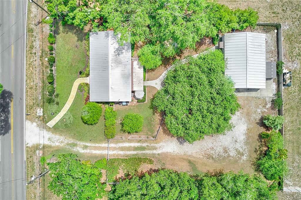 An aerial view shows a house and a detached garage on a tree-filled lot — 175 RIVIERE ROAD, PALM HARBOR, FL