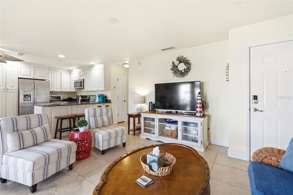 A living room with striped chairs, a wooden coffee table, and an open kitchen — 5191 SALMON DRIVE SE UNIT B, ST PETERSBURG, FL