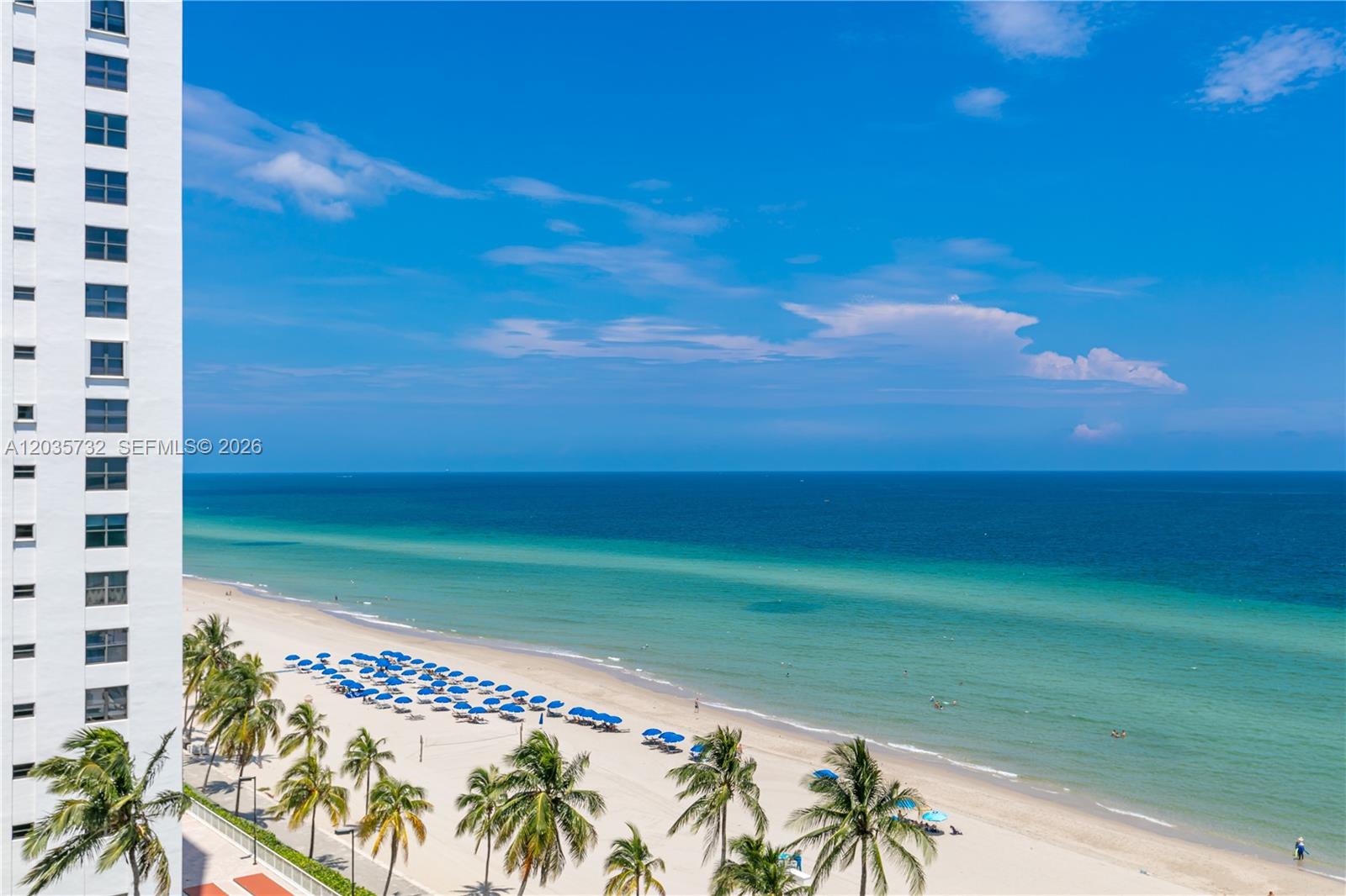 A high-angle view shows a white building exterior overlooking a sandy beach and ocean — 2501 S Ocean Dr # 1008, Hollywood FL 33019, HOLLYWOOD, FL