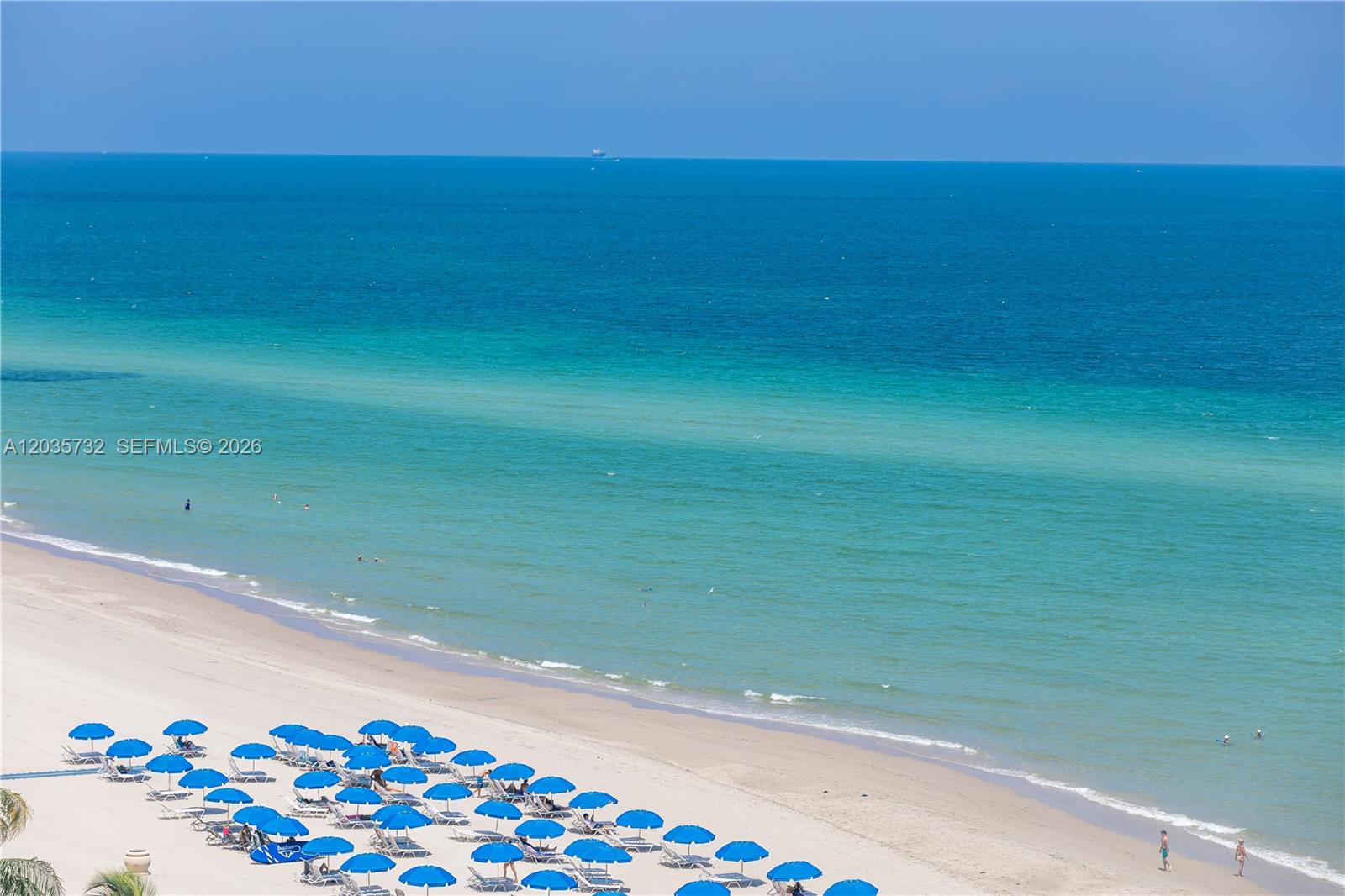 An aerial view of a sandy beach with rows of blue umbrellas and the ocean — 2501 S Ocean Dr # 1008, Hollywood FL 33019, HOLLYWOOD, FL