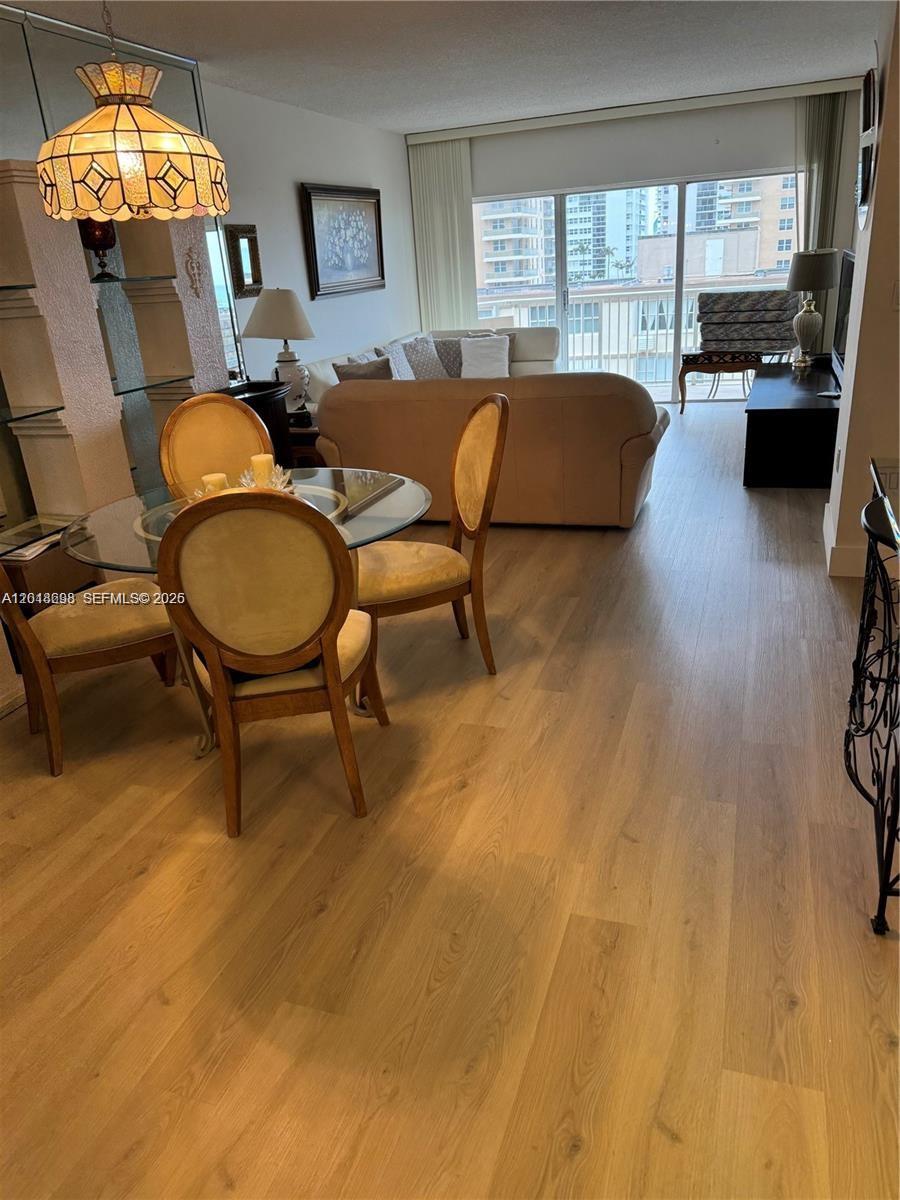 A dining area with a glass table and chairs opens into a living room — 1950 S Ocean Dr # 4D, Hallandale Beach FL 33009, HALLANDALE BEACH, FL
