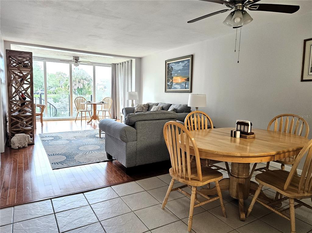 A living and dining area features tile and wood flooring, a ceiling fan, and windows — 1800 MARINER DRIVE UNIT 9, TARPON SPRINGS, FL