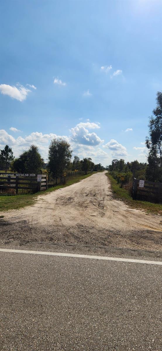A dirt road leads from a paved street through a wooden gate into a field — 48345 Bermont Rd, Punta Gorda FL 33982, PUNTA GORDA, FL