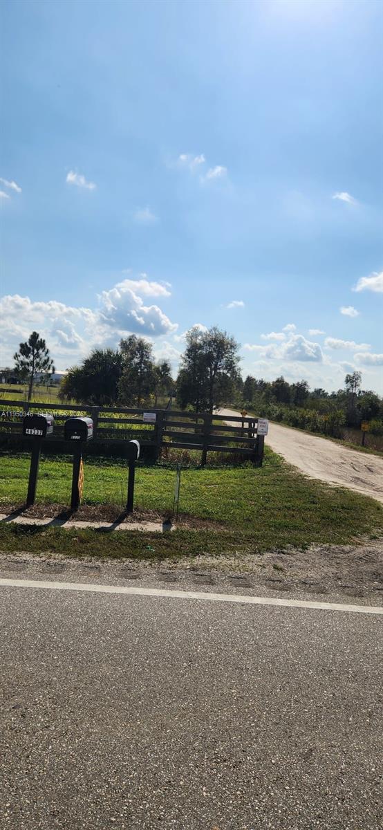 A dirt driveway leads past a wooden fence and mailboxes toward a rural landscape — 48345 Bermont Rd, Punta Gorda FL 33982, PUNTA GORDA, FL