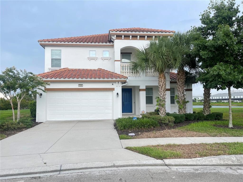 A two-story house with a white exterior, red tile roof, and a two-car garage — 5426 OAKGRAIN COURT, DAVENPORT, FL
