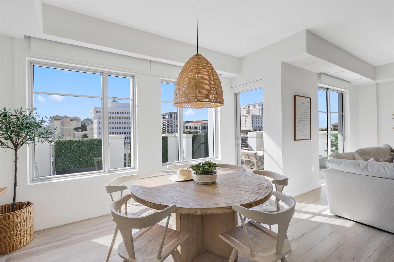 A dining area features a round wooden table, woven pendant light, and large windows — 155 E Boca Raton Road # 601, Boca Raton FL 33432, BOCA RATON, FL