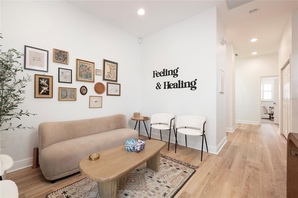 A waiting room features a beige sofa, two white chairs, a coffee table, and wall art — 801 2ND STREET N UNIT C, SAFETY HARBOR, FL