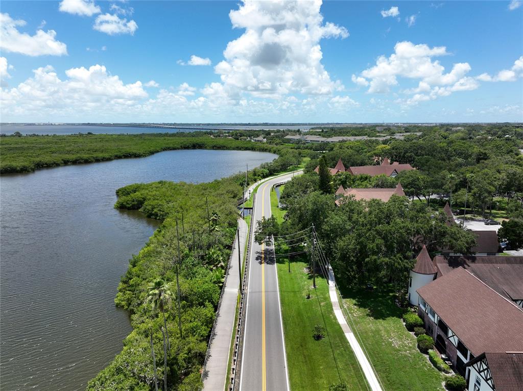 An aerial view shows a road running between a body of water and residential buildings — 801 2ND STREET N UNIT C, SAFETY HARBOR, FL
