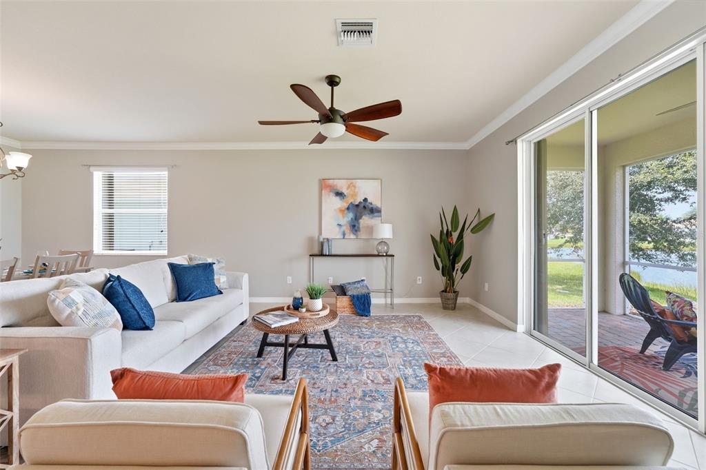 A living room features a white sofa, two armchairs, a patterned rug, and sliding glass doors — 4993 BRITTAIN WAY, NORTH PORT, FL