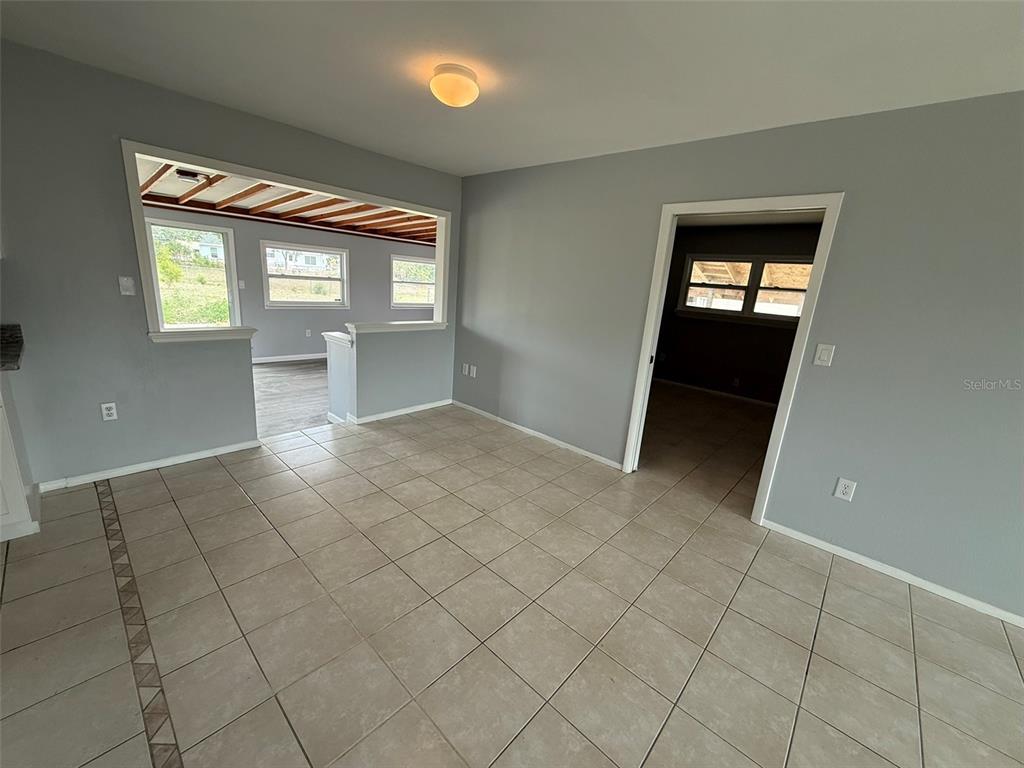 A tiled room with gray walls features a large opening to another space — 3236 MONTCLAIR CIRCLE, NORTH PORT, FL