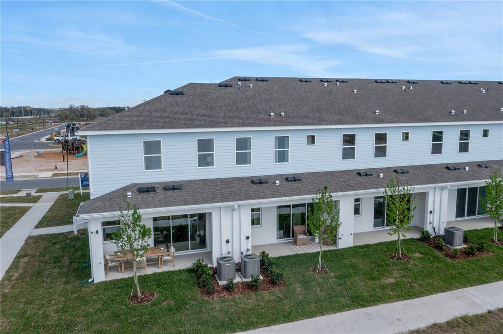 An aerial view of the rear exterior of a two-story townhouse with a patio — 31825 KESTREL CALLING DRIVE, SAN ANTONIO, FL