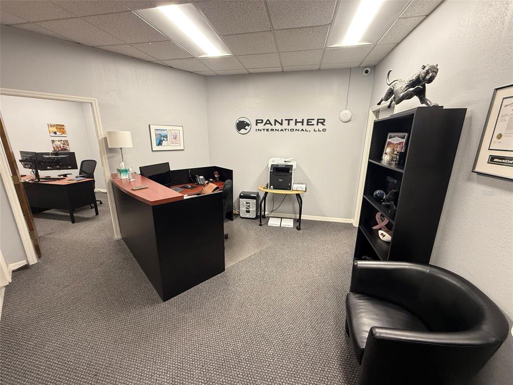 An office space features a reception desk, a black bookshelf, and a small printer stand — 2841 EXECUTIVE DRIVE UNIT 200, CLEARWATER, FL
