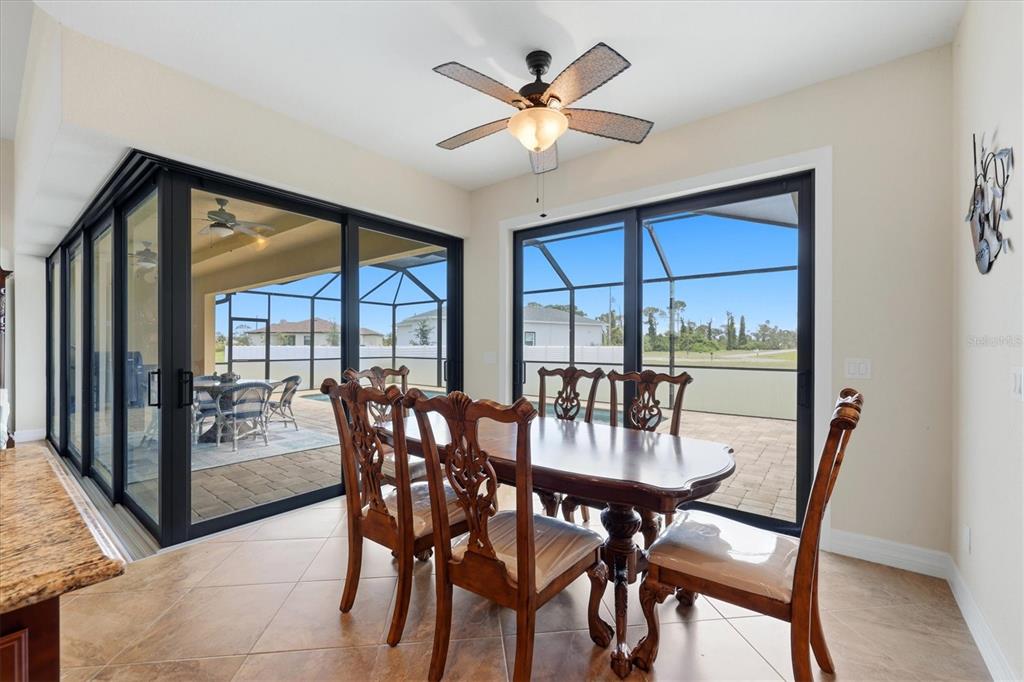 A dining area features a wooden table, ornate chairs, tile flooring, and sliding glass doors — 60 HARNESS ROAD, PLACIDA, FL