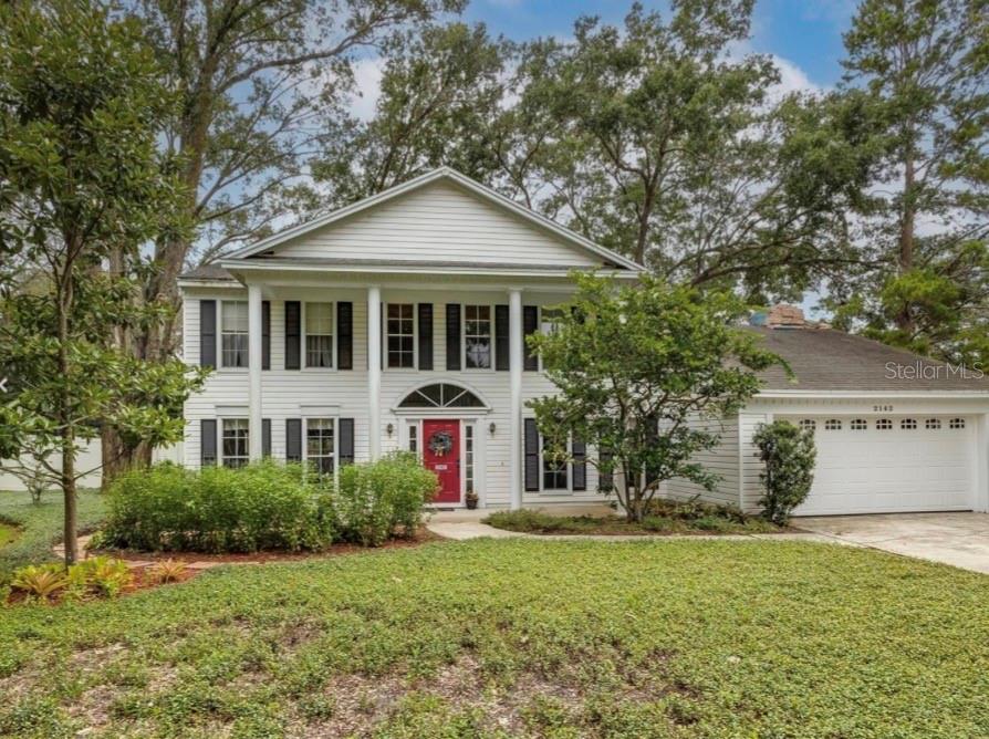 A two-story white house with black shutters, a red front door, and a two-car garage — 2142 COUNTRY SIDE DRIVE, APOPKA, FL