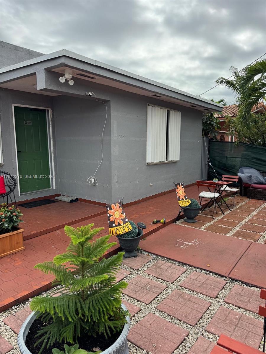 A gray house exterior features a green door, a window with shutters, and a patio — 2737 NW 13th Ave, Miami FL 33142, MIAMI, FL