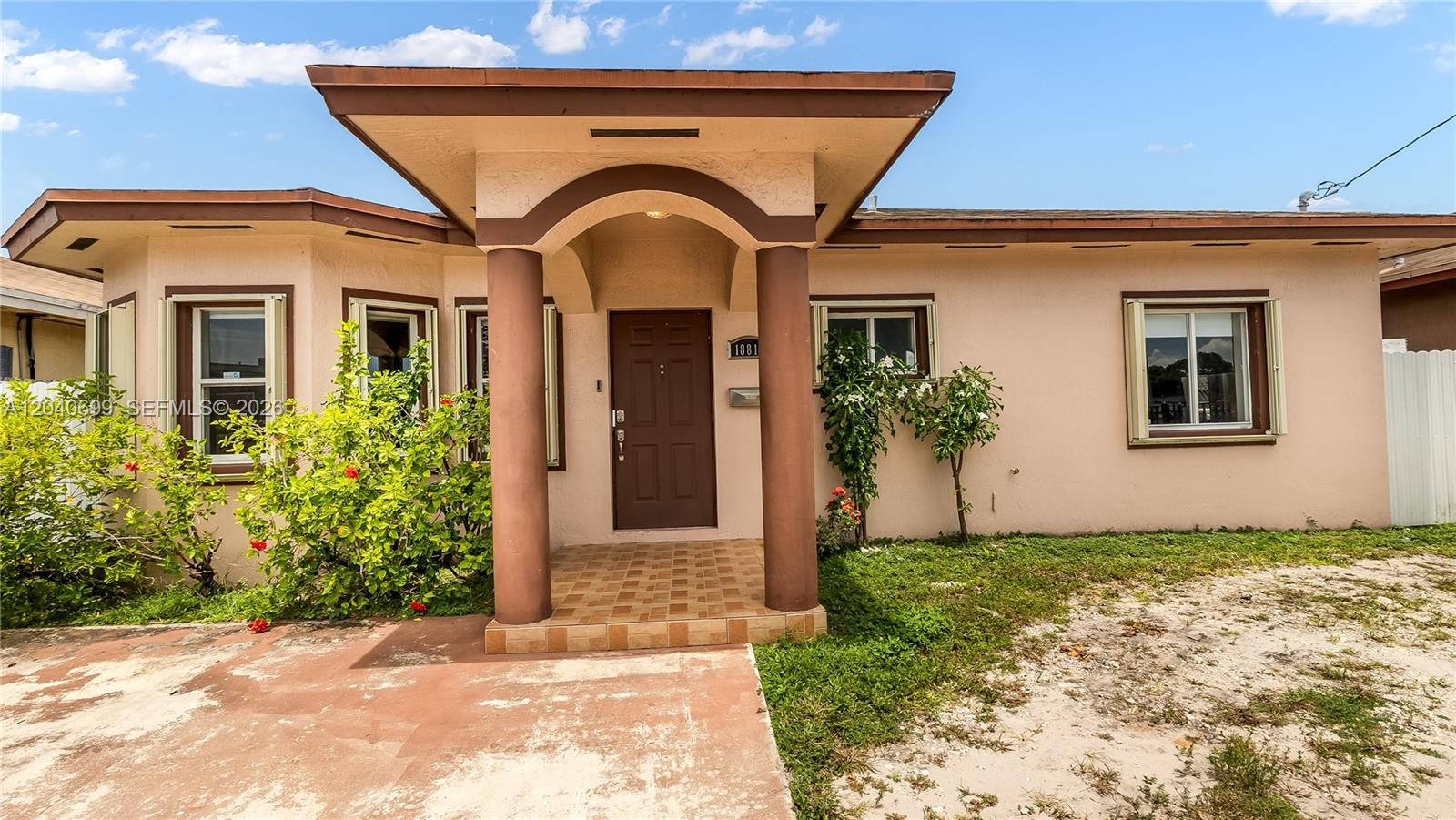 A single-story house with a tan stucco exterior, a covered entryway, and two brown columns — 18815 NW 37th Ave, Miami Gardens FL 33056, MIAMI GARDENS, FL