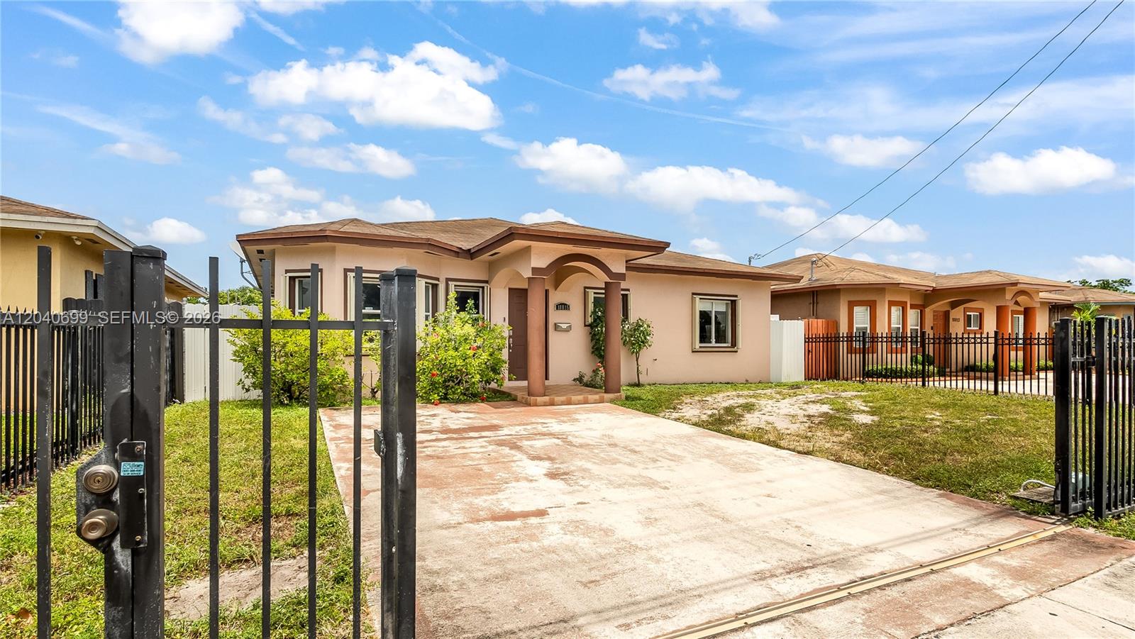 A single-story house with a concrete driveway and a black metal fence in front — 18815 NW 37th Ave, Miami Gardens FL 33056, MIAMI GARDENS, FL