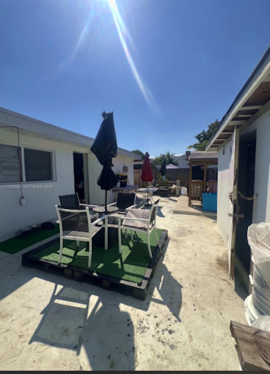 An outdoor patio area features a small table with chairs on a pallet platform — 2373 NW 33rd St, Miami FL 33142, MIAMI, FL