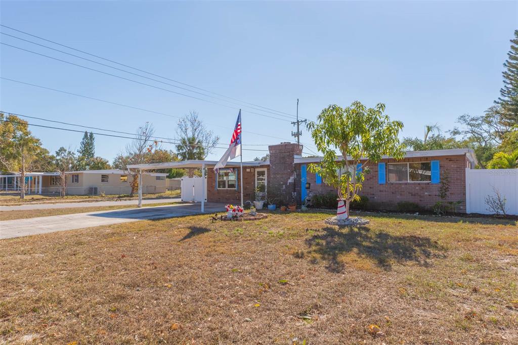 A single-story brick house features a carport, a front yard, and blue window shutters — 4102 W FAIRVIEW HEIGHTS, TAMPA, FL