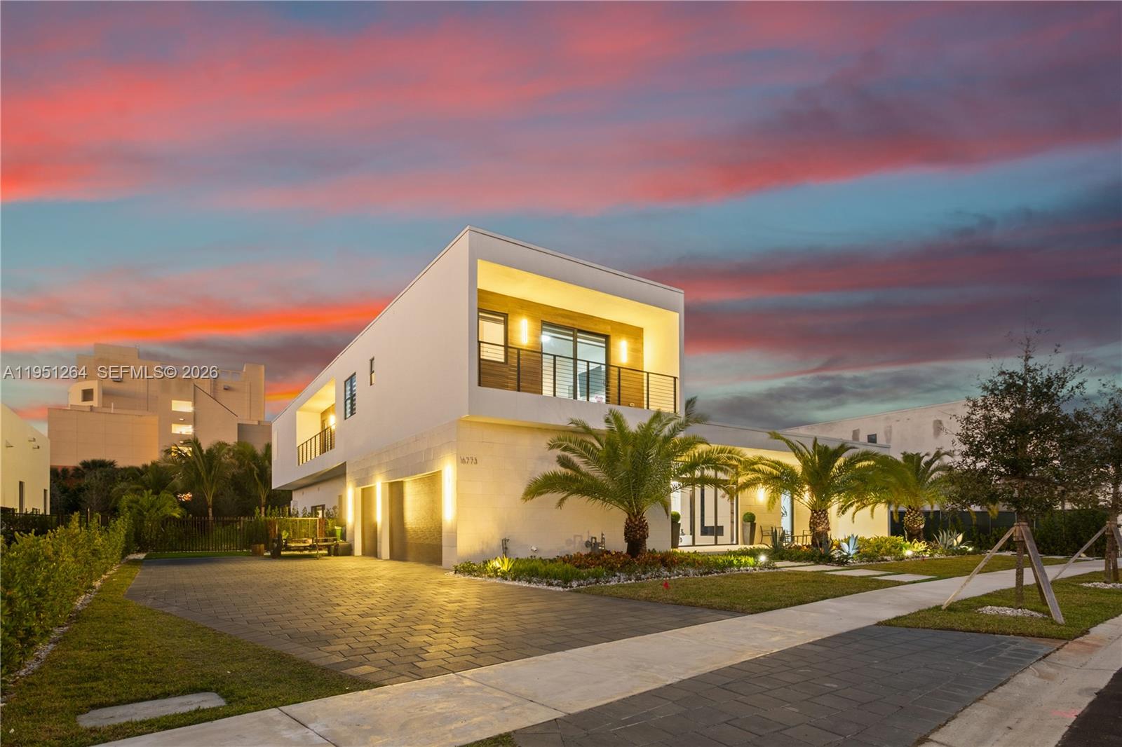 A modern two-story house with a paved driveway, palm trees, and a sunset sky — 16773 S Botaniko Dr S, Weston FL 33326, WESTON, FL