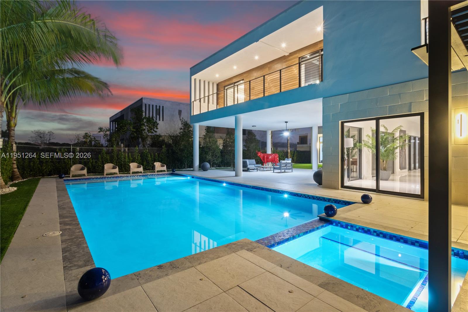 A modern two-story house features a swimming pool, hot tub, and covered patio at dusk — 16773 S Botaniko Dr S, Weston FL 33326, WESTON, FL
