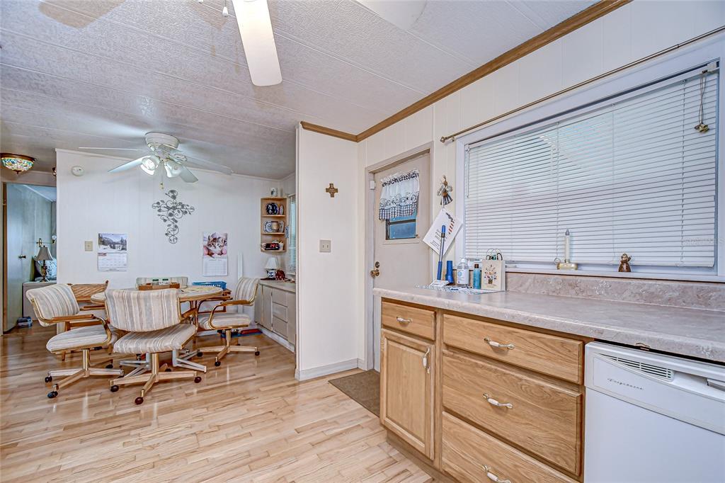A kitchen with wood cabinets, light countertops, and a dining area with a ceiling fan — 39443 ELGIN DRIVE, ZEPHYRHILLS, FL