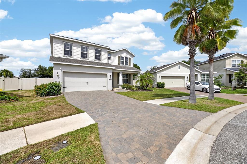 A two-story suburban house with a paved driveway, a two-car garage, and palm trees — 12234 BLUE PACIFIC DRIVE, RIVERVIEW, FL