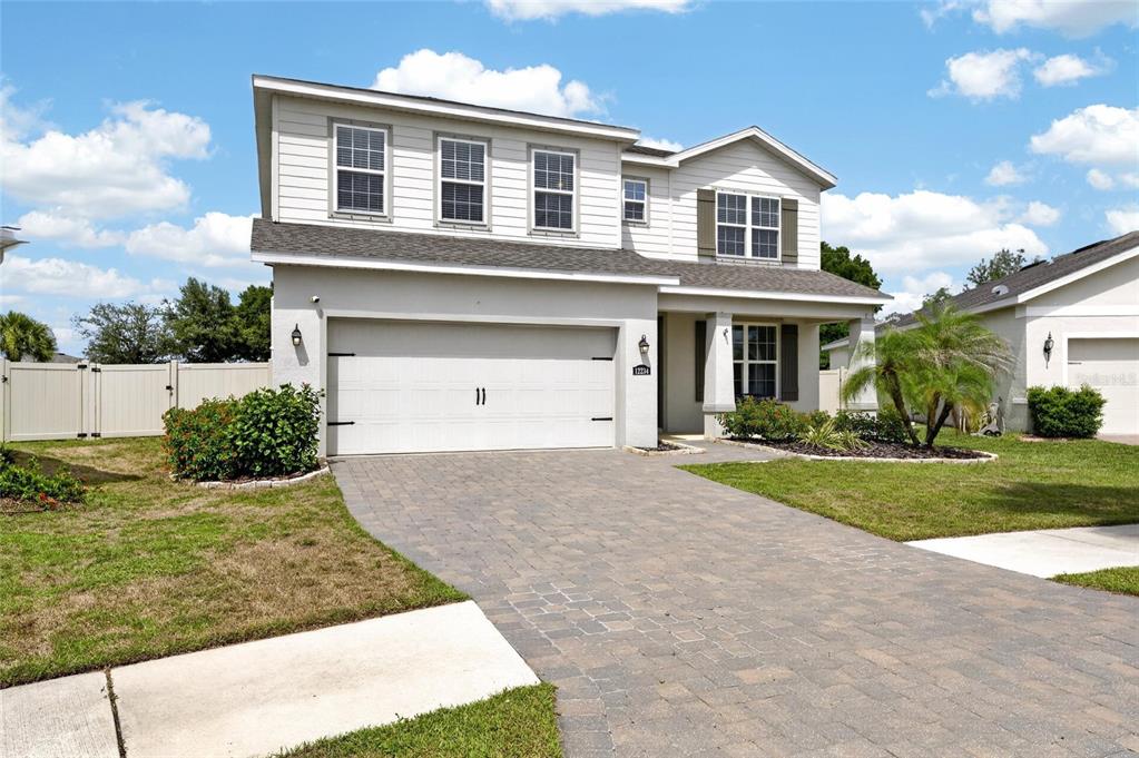 A two-story house with a white garage, gray siding, and a paved driveway — 12234 BLUE PACIFIC DRIVE, RIVERVIEW, FL
