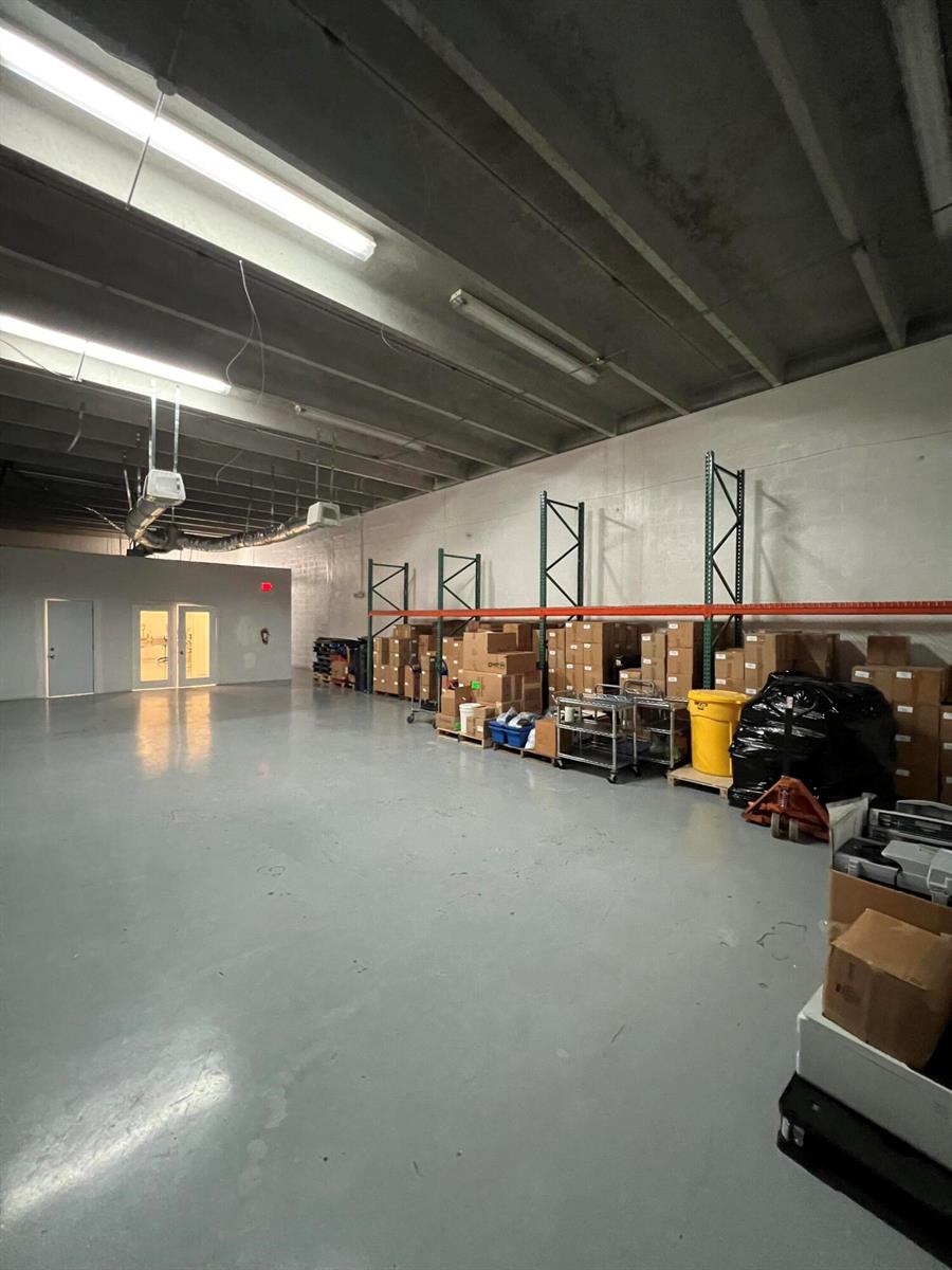 A warehouse space features a gray concrete floor, industrial lighting, and metal storage shelving units — 3335 NW 74th Avenue # 3335, Miami FL 33122, MIAMI, FL