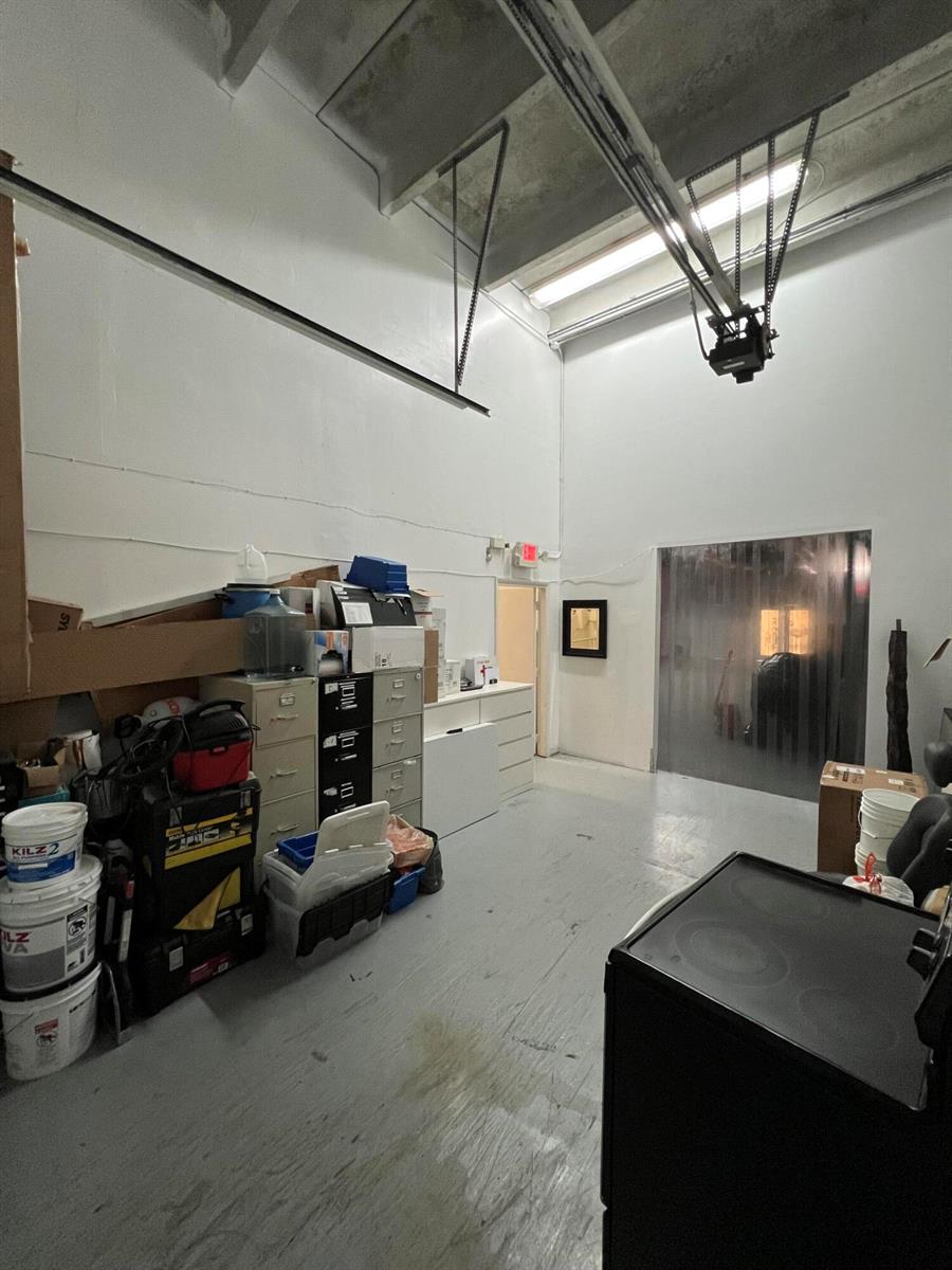 A high-ceilinged storage room with white walls, a concrete floor, and various stacked items — 3335 NW 74th Avenue # 3335, Miami FL 33122, MIAMI, FL