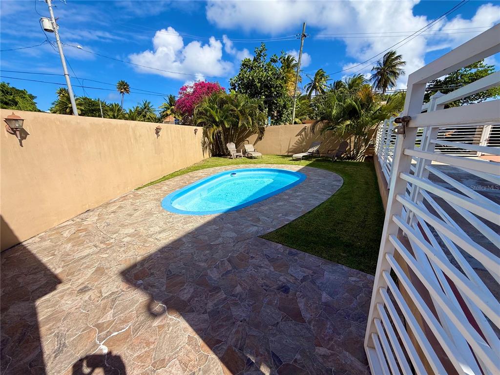 An outdoor patio features a small oval swimming pool, stone pavers, and lounge chairs — carr #3 JUST 1 MINUTE BEACH, PATILLAS, PR