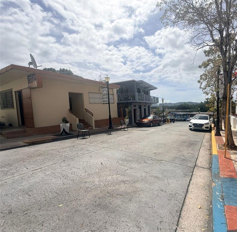 A street view shows a tan building and a gray two-story building with parked cars — 4 Calle Mateo Fajardo CALLE MATEO FAJARDO, HORMIGUEROS, PR