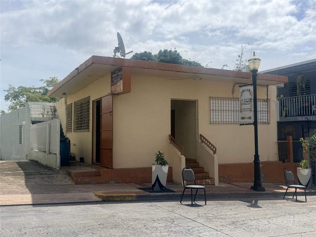 A single-story tan commercial building with a flat roof, entrance stairs, and a satellite dish — 4 Calle Mateo Fajardo CALLE MATEO FAJARDO, HORMIGUEROS, PR